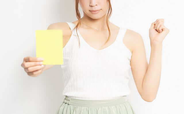 イエローカードを手に持つ若い女性のイメージ